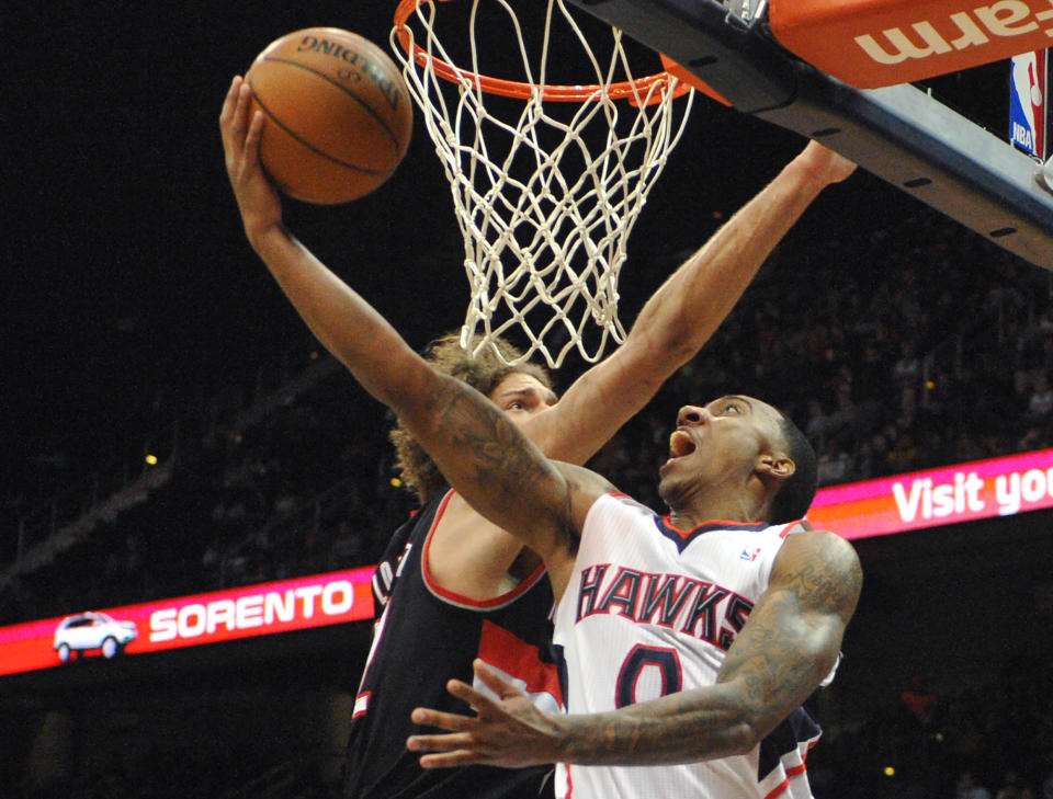 Atlanta Hawks' Jeff Teague (0) shoots the layup around Portland Trail Blazers' Robin Lopez (42) in the first half of their NBA basketball game Thursday, March 27, 2014, in Atlanta. (AP Photo/David Tulis)