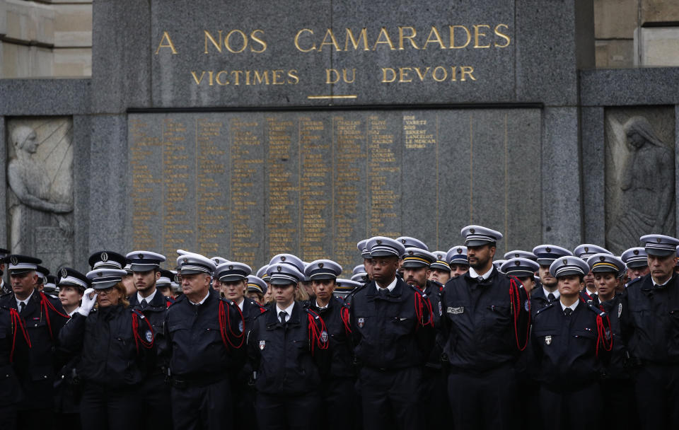 Police officers stand at attention in the courtyard of the Paris police headquarters during a ceremony for the four victims of last week's knife attack Tuesday, Oct. 8, 2019 in Paris. France's presidency says the four victims of last week's knife attack at the Paris police headquarters will be posthumously given France's highest award, the Legion of Honor. (AP Photo/Francois Mori)