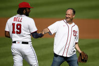 Doug Emhoff, second gentleman of the United States, right, shakes hands with Washington Nationals first baseman Josh Bell (19) after he threw out the ceremonial first pitch before a baseball game between the Nationals and the Colorado Rockies, Saturday, Sept. 18, 2021, in Washington. (AP Photo/Nick Wass)