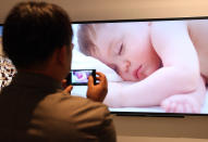 BERLIN, GERMANY - AUGUST 31: A visitor takes a photo of a Sony Bravia television during the Internationale Funkausstellung (IFA) 2012 consumer electronics trade fair on August 31, 2012 in Berlin, Germany. Microsoft, Samsung, Sony, Panasonic and Philips are amongst many of the brands showcasing their latest consumer electronics hardware, software and gadgets to members of the public from August 31 to September 5. (Photo by Adam Berry/Getty Images)