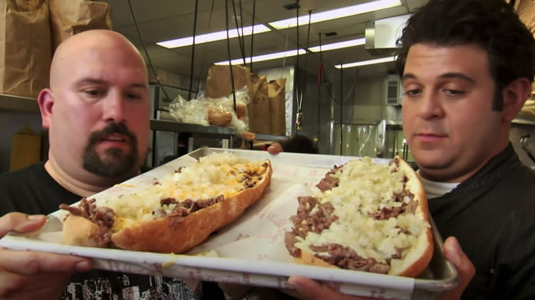 Adam Richman and owner with cheesesteaks