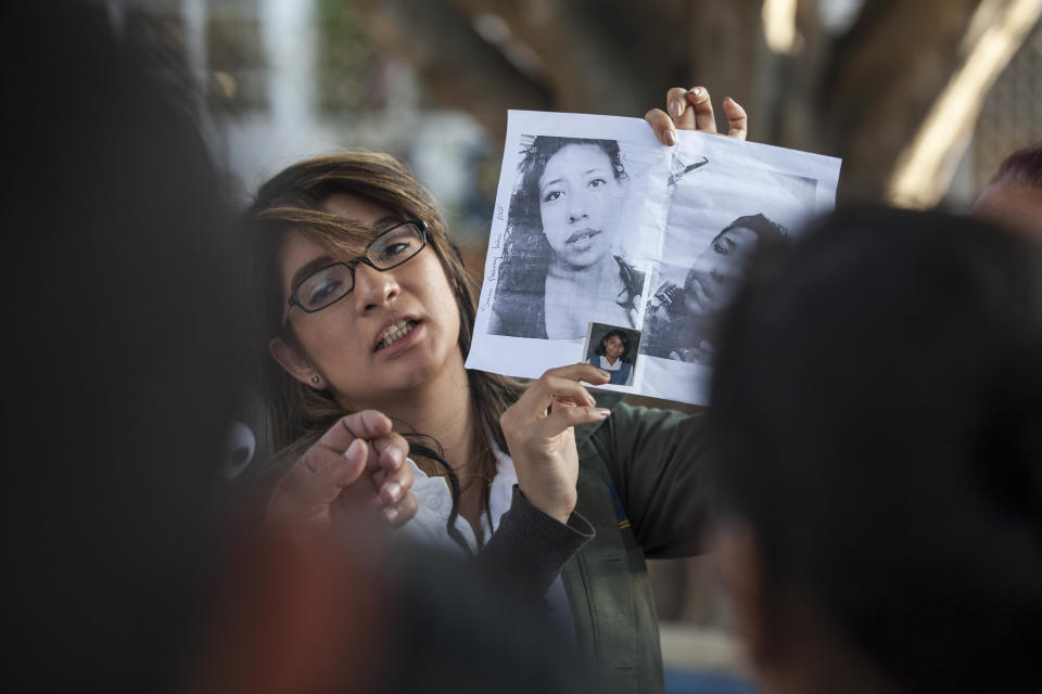 In this March 8, 2017 photo, a doctor shows photos of the victims in an attempt to identify them after a fire at the Virgen de la Asuncion Safe Home, outside the Roosevelt Hospital in Guatemala City. When firefighters entered the home for troubled youths, they discovered more than two dozen girls on the floor of a locked room, most of them dead. (AP Photo/Moises Castillo)