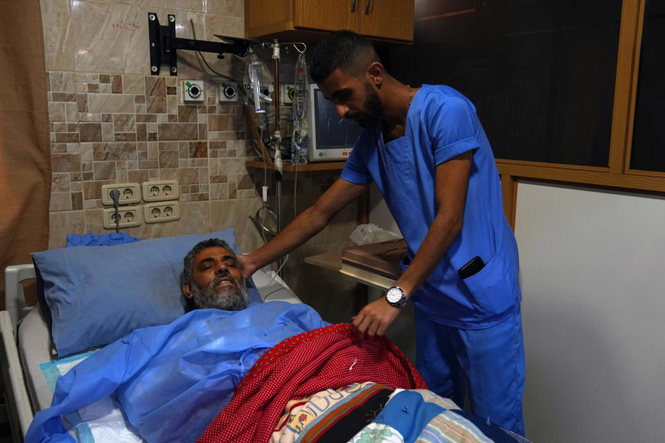 A health worker treats Yousof Moshairfi, 61, who was wounded during clashes between members of the Palestinian Fatah group and Islamist militants in the Palestinian refugee camp of Ein el-Hilweh, at a hospital in the southern port city of Sidon, Lebanon, Sunday, Sept. 10, 2023. Islamist factions in Lebanon's largest Palestinian refugee camp said Sunday they will abide by a cease-fire after three days of clashes killed at least five people and left hundreds of families displaced. (AP Photo/Bilal Hussein)