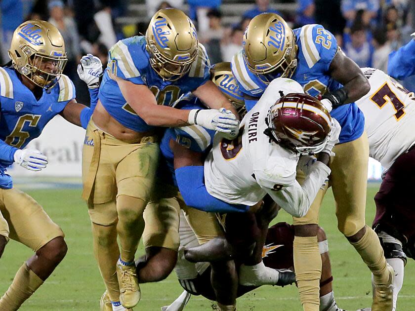 Pasadena, CA - THe UCLA defense puts the clamps on ASU wide receiver Troy Omeire.