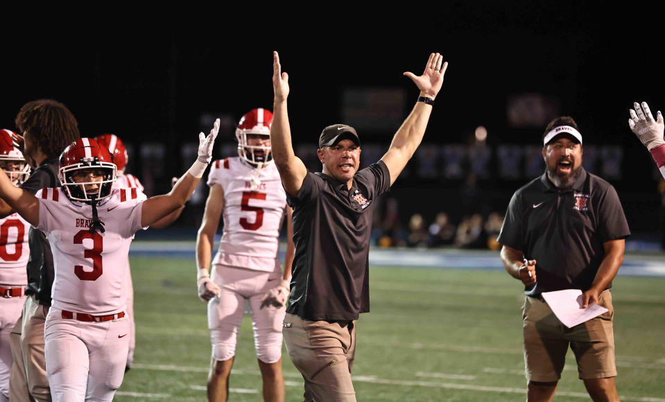 Indian Hill coaches and players react after their 21-3 win over Wyoming Friday, Oct. 13, 2023.