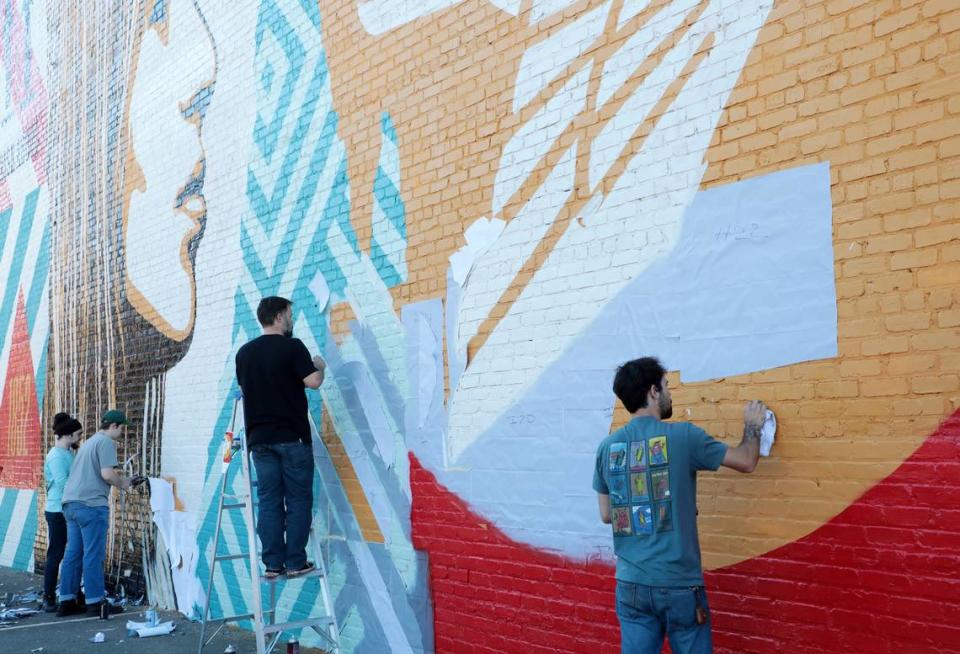 Artists help paint a mural Sunday designed by Shepherd Fairey in downtown Rock Hill.