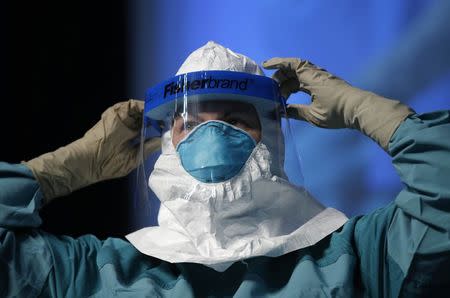 Barbara Smith, a registered nurse with Mount Sinai Medical Health Systems, St. Luke's and Roosevelt Hospitals in New York, demonstrates putting on personal protective equipment (PPE) during an Ebola educational session for healthcare workers in New York, in this file photo taken October 21, 2014. REUTERS/Mike Segar/Files