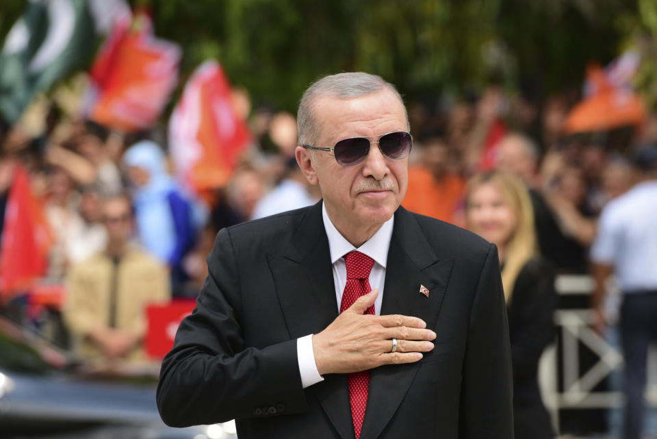 Turkish President Recep Tayyip Erdogan greets the people as arrives in the Turkish occupied area of the divided capital Nicosia, Cyprus, Monday, June 12, 2023. Erdogan is in the Turkish occupied area of north part of the Cyprus island on his first trip after his re-election after the May 28 presidential election. (AP Photo/Nedim Enginsoy)