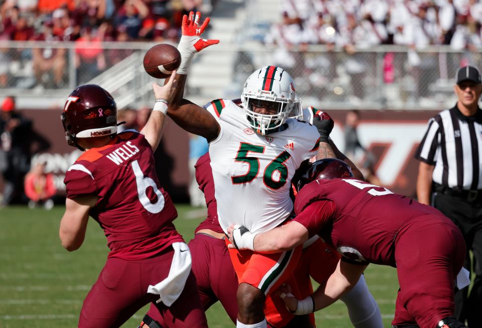 Miami defensive lineman Leonard Taylor tries to block the pass from Virginia Tech quarterback Grant Wells.