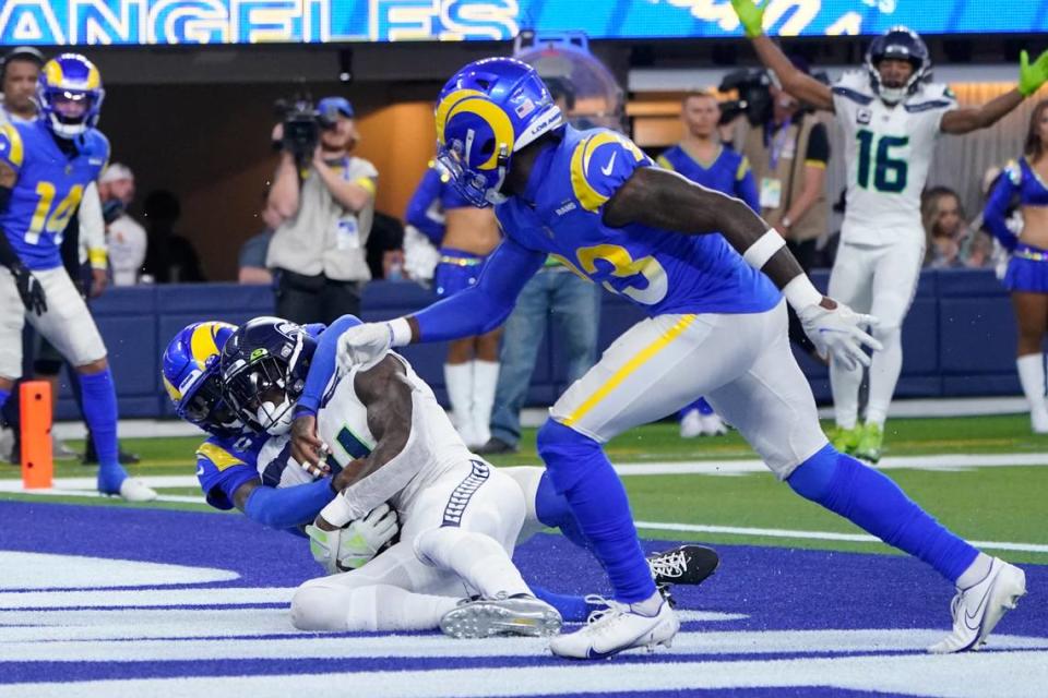 Seattle Seahawks wide receiver DK Metcalf catches a touchdown pass as Los Angeles Rams defensive back Jalen Ramsey, left, and safety Nick Scott (33) defend during the second half of an NFL football game Sunday, Dec. 4, 2022, in Inglewood, Calif. (AP Photo/Marcio Jose Sanchez)