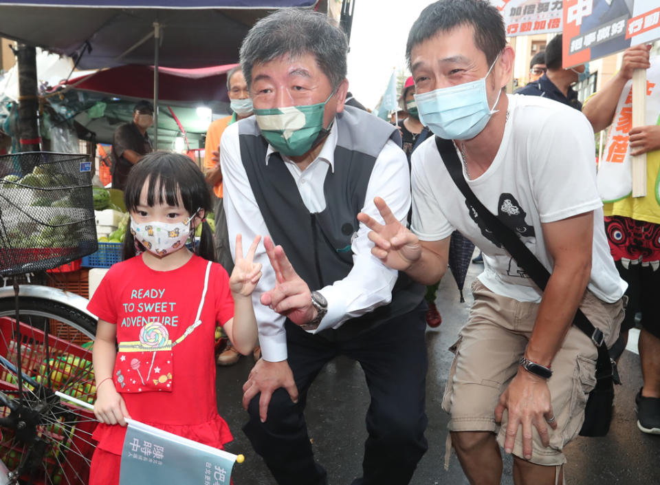 陳時中(中)主張讓台北變成「孩子快樂城」，喊出何不「先玩，再寫功課」。圖為他15日傍晚前往永春市場掃街拜票。（鄭任南攝）