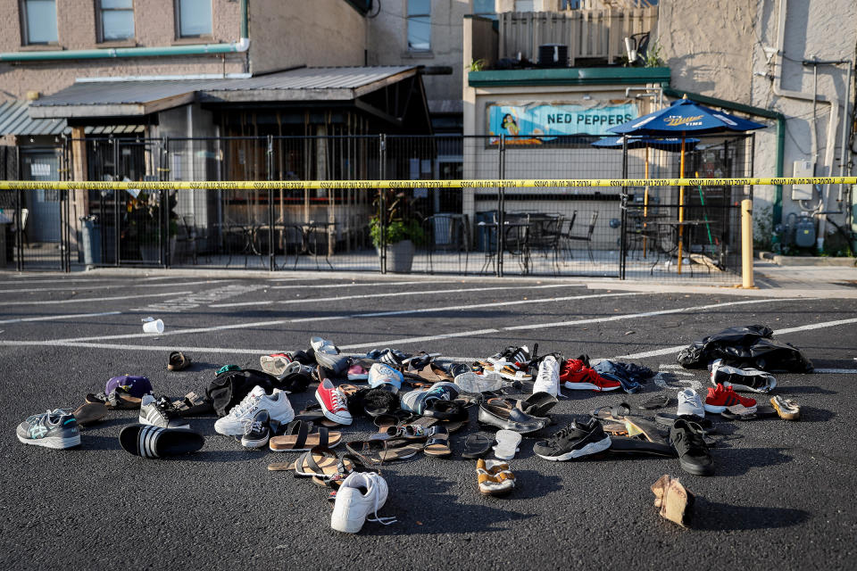 Shoes are piled outside the scene of a mass shooting including Ned Peppers bar, Sunday, Aug. 4, 2019, in Dayton, Ohio. Several people in Ohio have been killed in the second mass shooting in the U.S. in less than 24 hours, and the suspected shooter is also deceased, police said. | John Minchillo—AP