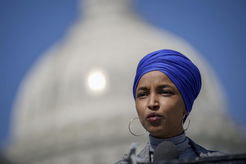 Rep. Ilhan Omar wearing a blue headcovering, in front of the U.S. Capitol.
