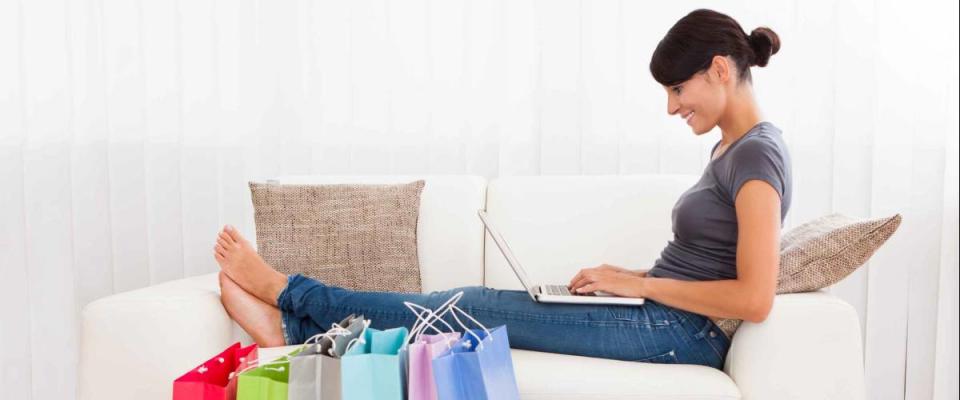 Young Woman Sitting On Couch Shopping Online