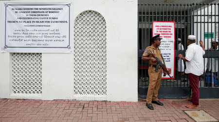 Sri Lankan police officer stand guard in front of a mosque as a Muslim man walks past him during the Friday prayers at a mosque, five days after a string of suicide bomb attacks on Catholic churches and luxury hotels across the island on Easter Sunday, in Colombo, Sri Lanka April 26, 2019. REUTERS/Dinuka Liyanawatte