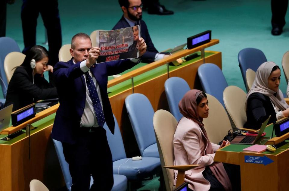 Israel’s ambassador to the United Nations holds a sign in support of women’s’ rights in Iran.