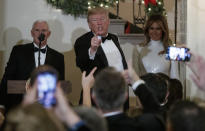 President Donald Trump, joined by Vice President Mike Pence, left, and first lady Melania Trump, right, acknowledges the crowd during the Congressional Ball in the Grand Foyer of the White House in Washington, Saturday, Dec. 15, 2018. (AP Photo/Carolyn Kaster)