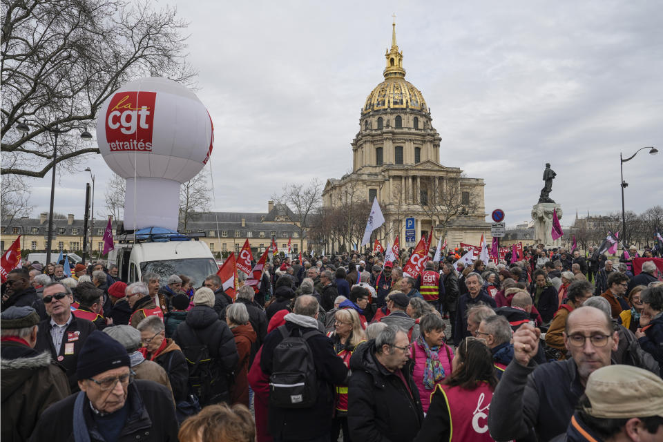 People stage a protest against the retirement bill in Paris, Monday, March 20, 2023. France's government is fighting for its survival Monday against no-confidence motions filed by lawmakers who are furious that President Emmanuel Macron used special constitutional powers to force through an unpopular bill raising the retirement age from 62 to 64 without giving them a vote. Les Invalides in background. (AP Photo/Lewis Joly)