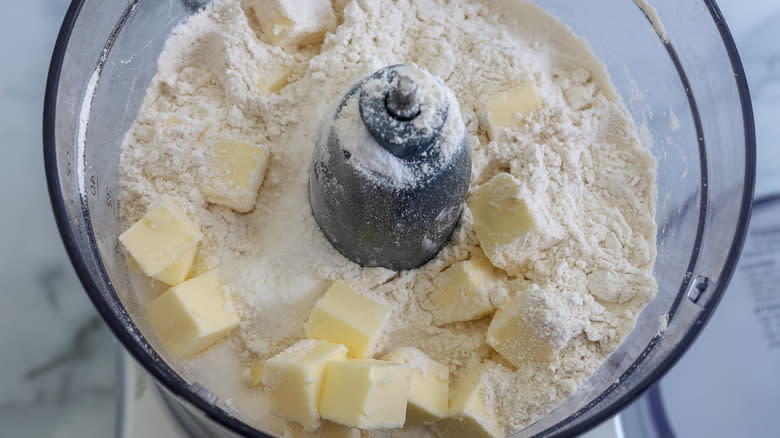 food processor with dry ingredients and butter in it