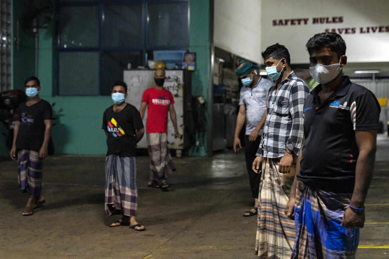 SINGAPORE - APRIL 24: Migrant workers wearing protective face masks at a factory converted into a dormitory receive sahur (pre-dawn meal) for Muslim migrant workers from non-governmental organisations on April 24, 2020 in Singapore. This meal will be the first Ramadan meal for Muslim migrant workers. (Photo by Ore Huiying/Getty Images)
