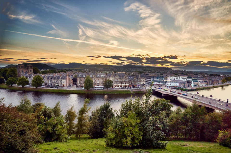 A panoramic view of a city on a riverbank.