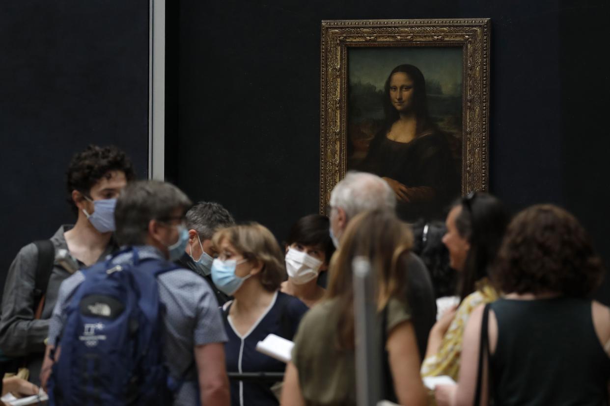 Journalists stand in front of Leonardo da Vinci's Mona Lisa during a visit of the Louvre museum ahead of its reopening next July 6, in Paris, France on Tuesday, June 23, 2020. Before mass tourism came to a screeching halt with the coronavirus pandemic, the Louvre drew up to 50,000 visitors per day, and when they reopen on upcoming July 6, they are counting on the world’s most famous portrait, the “Mona Lisa” to help lure back visitors.