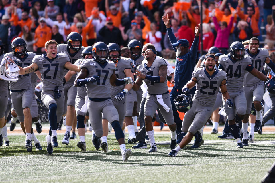 The Illinois team runs onto the field after kicking the game-winning field goal to beat 6th-ranked Wisconsin 24-23 on Saturday. (Getty)