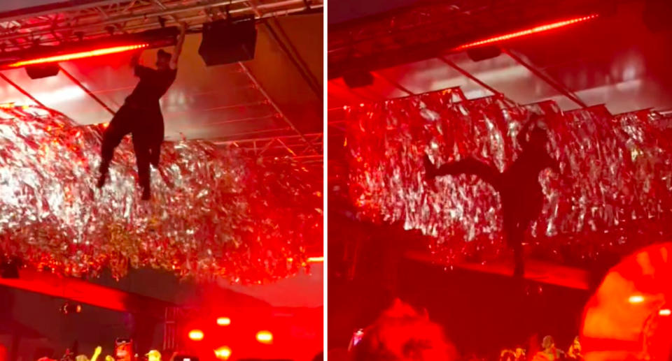 Man hanging from lighting structure at Sugar Mountain music event in Melbourne. 