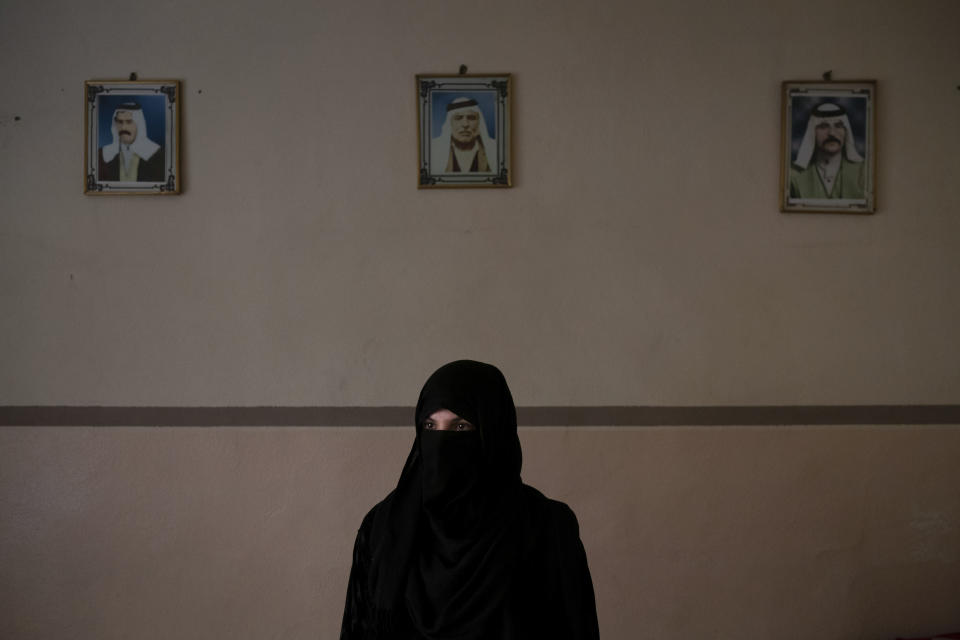 In this April 14, 2019 photo, Khadija Abd poses for a portrait in her family's house in Mosul, Iraq. On a chilly January evening, the Abd family had just finished supper at their farm when the two men with guns burst into the room. They said they were from the Iraqi army. In fact, they were Islamic State group militants who had come down from the surrounding mountains into Badoush with one thing on their mind: Revenge. (AP Photo/Felipe Dana)