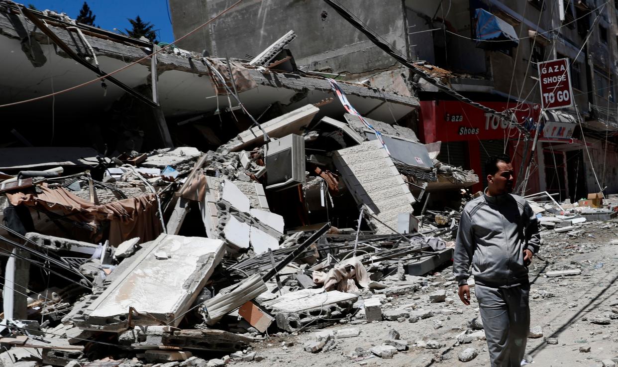 A man looks at the remains of a destroyed building after being hit by Israeli airstrikes in Gaza City on Thursday, May 13, 2021.