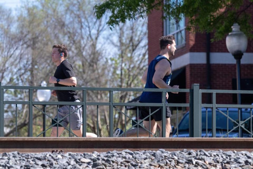 Two joggers pass each other on a path in South End on April 3, 2020.