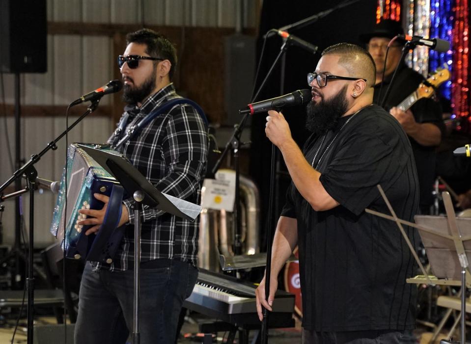 Cristobal Najar, left, and Alejandro Cresencio, right, are the newest members to join the local band Los Hermanos, formerly known as Los Hermanos Villegas. Najar, from Kalamazoo, plays the accordion in the band and provides vocals. Cresencio, from Detroit, provides lead vocals. They are pictured here performing during a concert earlier this July in Adrian at the River Raisin Ragtime Revue.