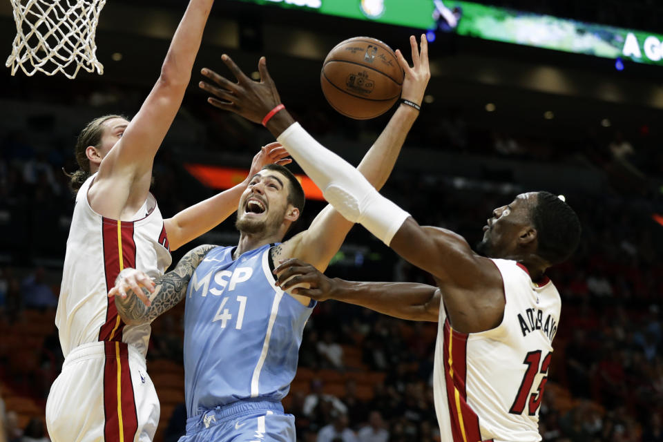 Minnesota Timberwolves forward Juancho Hernangomez (41) goes up for a shot against Miami Heat forwards Kelly Olynyk, left, and Bam Adebayo (13) during the first half of an NBA basketball game, Wednesday, Feb. 26, 2020, in Miami. (AP Photo/Wilfredo Lee)