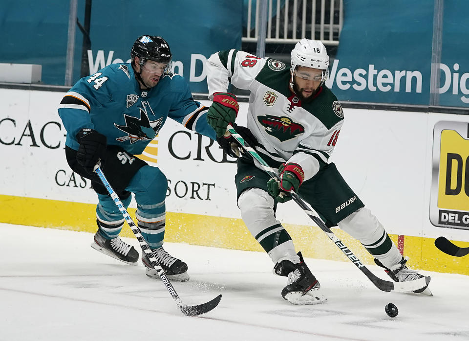 San Jose Sharks defenseman Marc-Edouard Vlasic (44) battles for the puck against Minnesota Wild left wing Jordan Greenway (18) during the second period of an NHL hockey game in San Jose, Calif., Monday, March 29, 2021. (AP Photo/Tony Avelar)