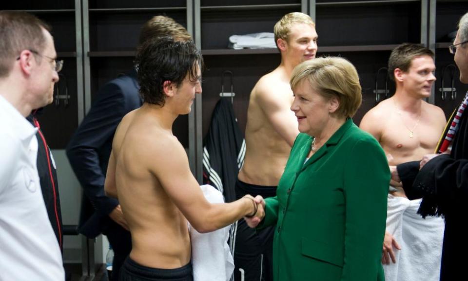 Merkel congratulates Mesut Özil in the dressing room after Germany beat Turkey in a Euro 2012 qualifier in Berlin in October 2010