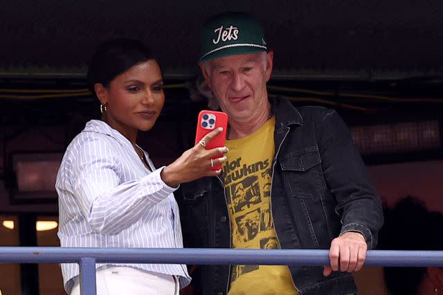 <p>Elsa/Getty </p> Mindy Kaling and John McEnroe at the 2023 US Open women's final