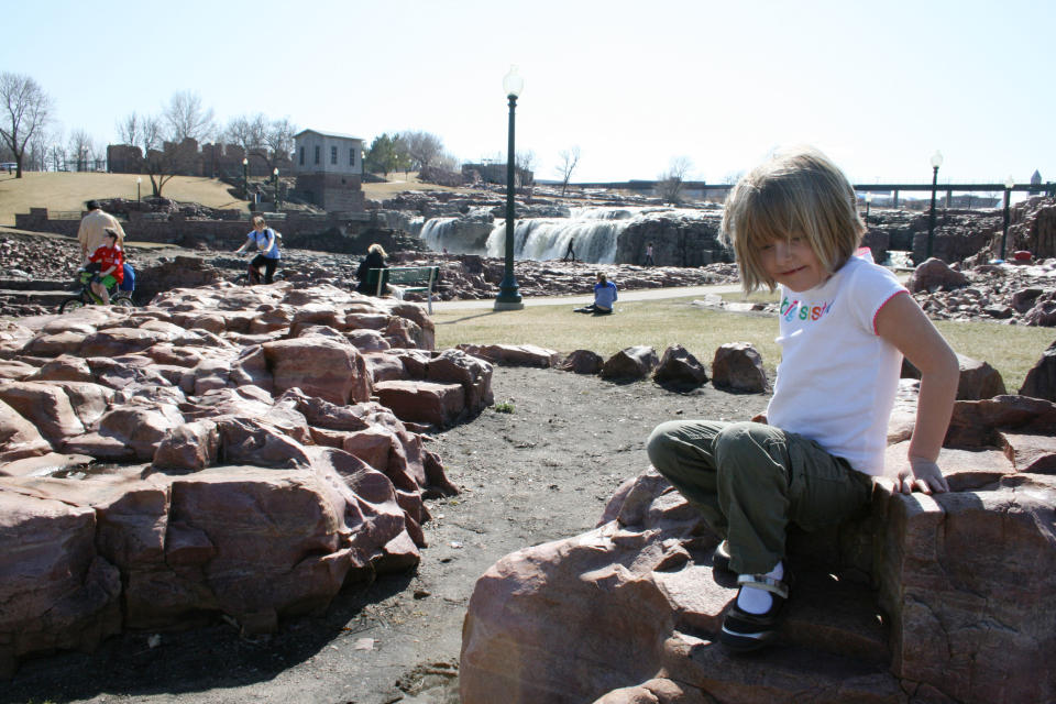 5-year-old Reagan Lovrien plays at Falls Park Tuesday, March 13, 2012, in Sioux Falls, S.D . Lovrien was at the park with her sister, 3-year-old Kinsey, and her grandmother, Sharon Lovrien of Sioux Falls. The two girls took advantage of a warm weather, playing on the rocks after eating ice cream. Clear skies and temperatures in the 70s graced areas from the Rocky Mountains to the Atlantic coast on Tuesday where residents are normally bundled up against cold March weather. Forecasters said spring is early and here to stay. Temperatures could remain unusually warm through the end of March. (AP Photo/Kristi Eaton)