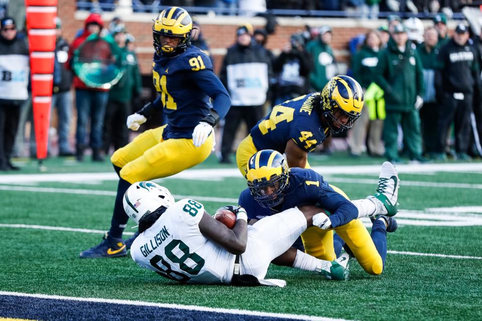 Michigan defensive back Ambry Thomas (1), linebacker Cameron McGrone (44) and defensive lineman Taylor Upshaw (91) tackle Michigan State tight end Trenton Gillison during the second half at Michigan Stadium in Ann Arbor, Saturday, Nov. 16, 2019.