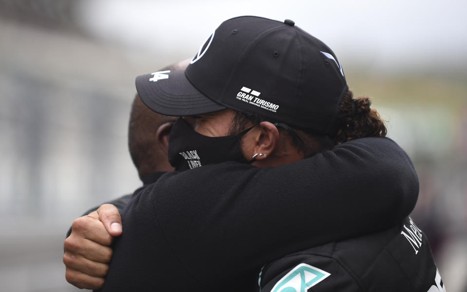 Mercedes driver Lewis Hamilton of Britain, right, is congratulated by his father Anthony Hamilton after his record breaking win at the Formula One Portuguese Grand Prix at the Algarve International Circuit in Portimao, Portugal, Sunday, Oct. 25, 2020. (Jorge Guerrero, Pool via AP)