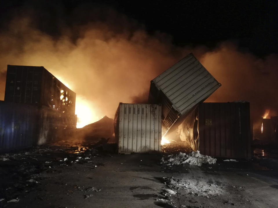 In this photo released by the Syrian official news agency SANA, flames rise from containers at the scene of missiles attack, at the seaport of the coastal city of Latakia, Syria, early Tuesday, Dec. 28, 2021. Israeli missiles fired from the Mediterranean struck the Syrian port of Latakia early Tuesday, igniting a fire in the container terminal, Syrian state media reported, in the second such attack on the vital facility this month. (SANA via AP)