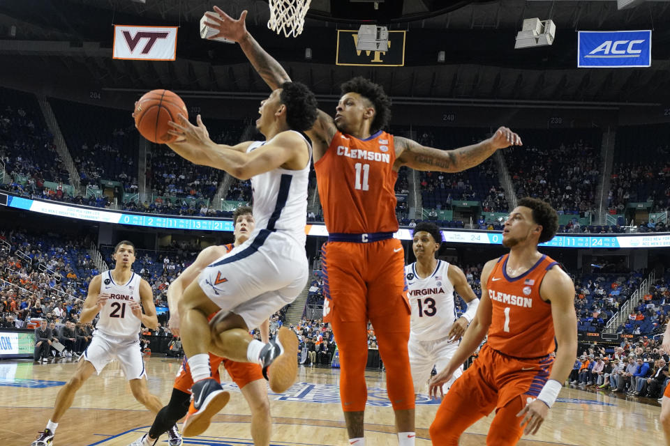 Virginia guard Kihei Clark, left, shoots as Clemson guard Brevin Galloway (11) defends during the first half of an NCAA college basketball game at the Atlantic Coast Conference Tournament in Greensboro, N.C., Friday, March 10, 2023. (AP Photo/Chuck Burton)