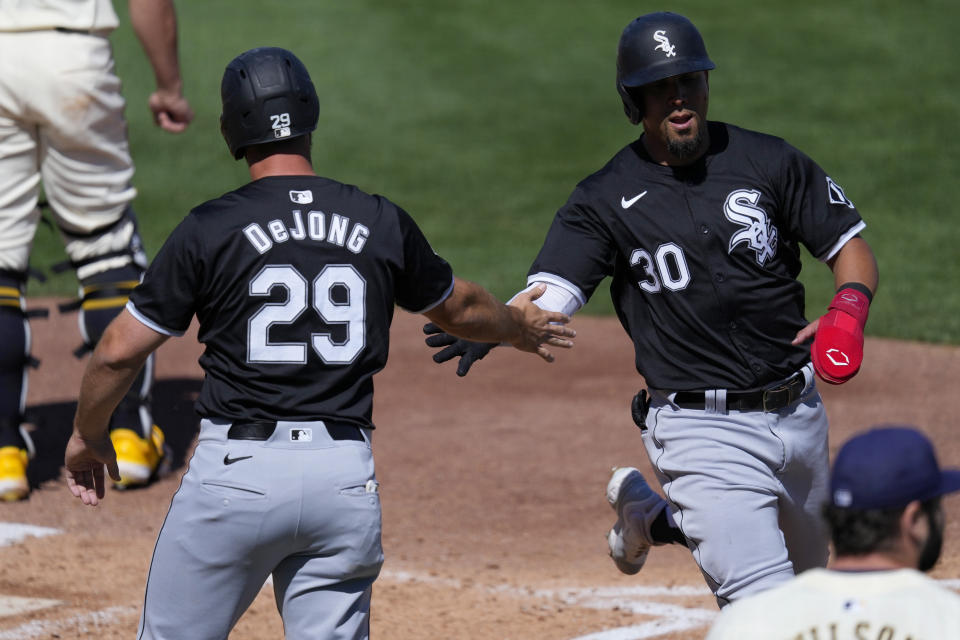 Chicago White Sox's Rafael Ortega crosses there plate as Paul DeJong celebrates after both scored on a fielding error by the Milwaukee Brewers during the third inning of a spring training baseball game, Wednesday, March 13, 2024, in Phoenix. (AP Photo/Matt York)