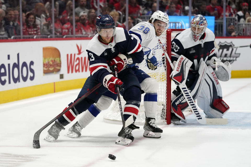 Washington Capitals defenseman Nick Jensen, left, skates past Tampa Bay Lightning left wing Brandon Hagel (38) and Capitals goaltender Darcy Kuemper (35) in the second period of an NHL hockey game, Friday, Nov. 11, 2022, in Washington. (AP Photo/Patrick Semansky)