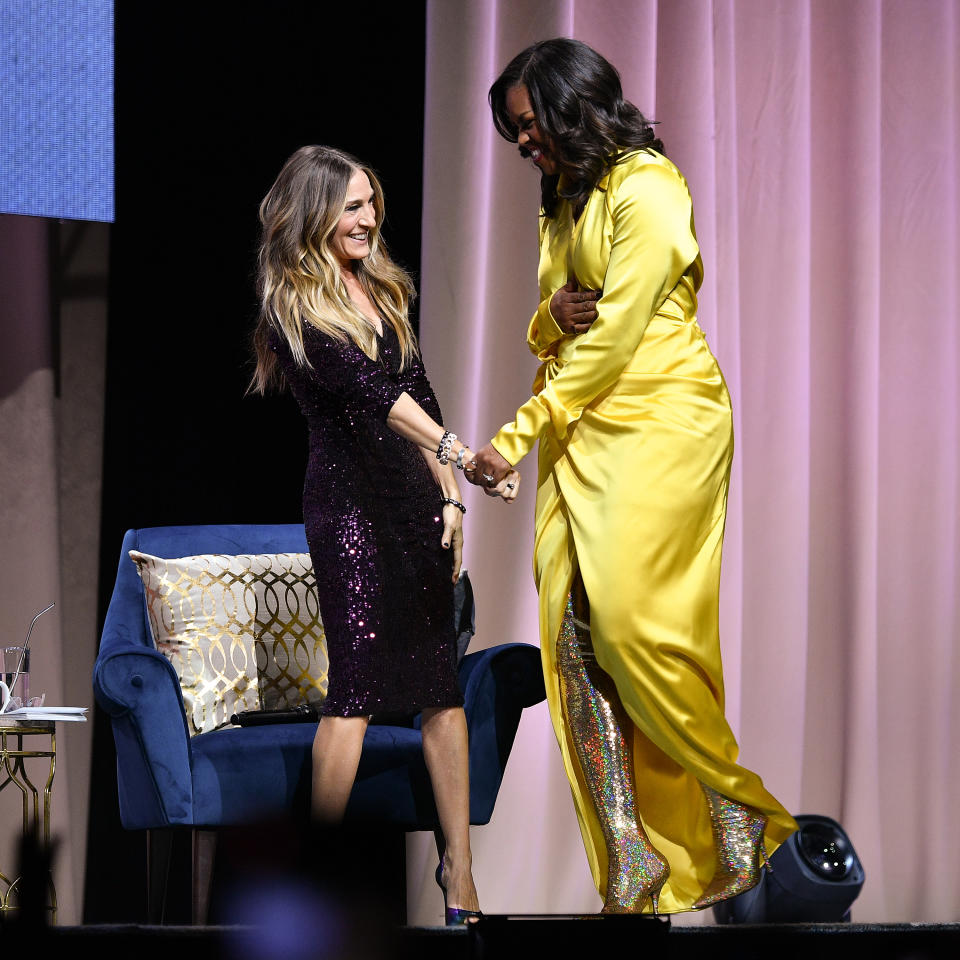 Michelle Obama clasps hands with interviewer Sarah Jessica Parker. [Photo: Getty[