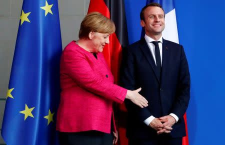 FILE PHOTO: German Chancellor Angela Merkel and French President Emmanuel Macron shake hands after a news conference at the Chancellery in Berlin, Germany, May 15, 2017. REUTERS/Fabrizio Bensch