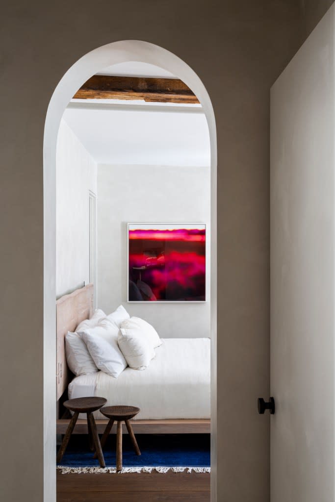 An arched doorway leads into this bedroom. Nina Poon