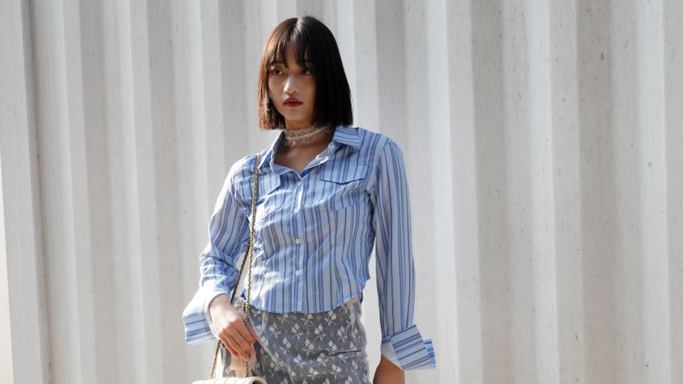 An attendees pairs her denim-trimmed skirt and striped shirt with a white lace choker. - Soeun Kim/CNN