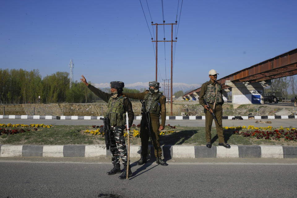 Indian paramilitary soldiers stand guard as an army convoy moves on a highway on the outskirts of Srinagar, Indian controlled Kashmir, Sunday, Feb. 7, 2019. Authorities in Indian portion of Kashmir have banned civilian traffic on Srinagar-Jammu national highway for two days in a week for the safe passage of Indian security force convoys. The move comes after the February 14 suicide bombing on a paramilitary convoy which killed more than 40 paramilitary personnel. (AP Photo/Dar Yasin)