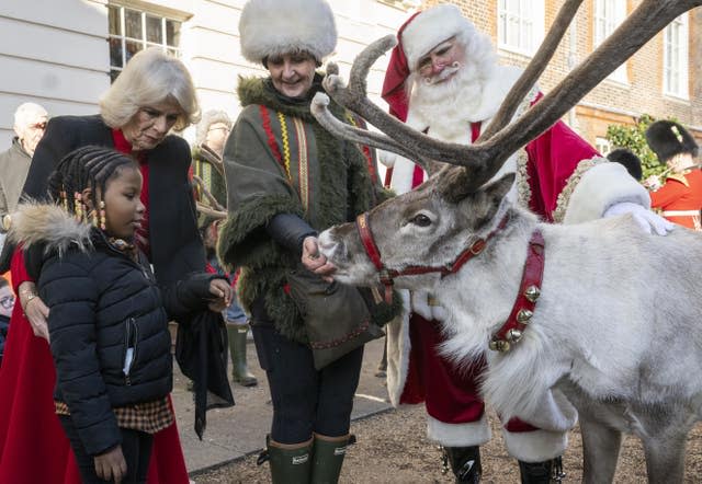 The Queen Consort, second left, and Mayann MacNeil-Thompson, seven, with Blixen the reindeer, as children supported by Helen and Douglas House and Roald Dahl’s Marvellous Children’s Charity, decorate the Christmas tree at Clarence House in London