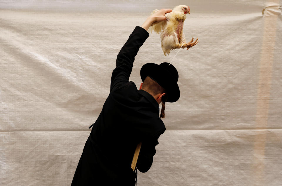 <p>An ultra-Orthodox Jewish man holds a chicken as he performs the Kaparot ritual, where white chickens are slaughtered as a symbolic gesture of atonement, ahead of Yom Kippur, the Jewish Day of Atonement, in Jerusalem’s Mea Shearim neighborhood, Sept. 27, 2017. (Photo: Ronen Zvulun/Reuters) </p>